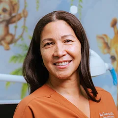 La Dra. Lisseth Abrego, odontopediatra, con uniforme naranja.
