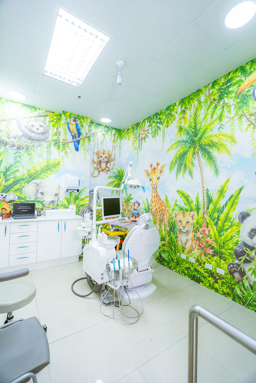 Vista del consultorio infantil con el mural de selva y el equipo dental